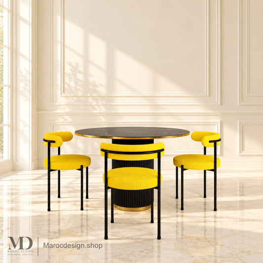 Table ronde ZÉNITH noire et dorée avec trois chaises jaunes visibles en intérieur lumineux — Maroc Design